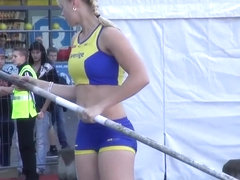 Hot blonde pole vaulter competes at a packed stadium