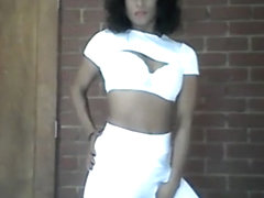 Sia in all white dancing, doing hair and playing with weights