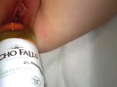 Inserting a bottle in a sluts pussy while she masturbates