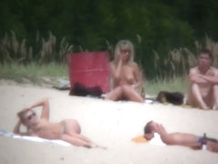 Nude milf and an acrobatic bitch move about on a nudists beach