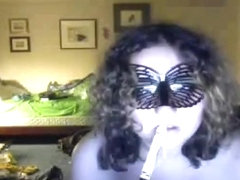 Fat curly haired masked brunette girl plays with her big boobs, while sucking a lollypop.