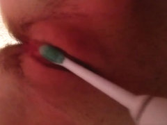 Pushing a toothbrush in her pussy and stimulating a clit