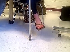 Girl dangling flip flops in class