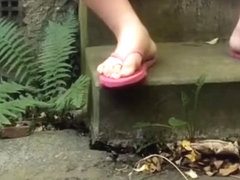 Chub wanks outside while wearing pink flipflops