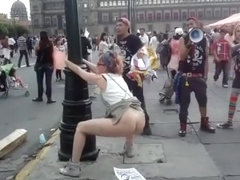 Female agitator pees and poops on a poster at a rally in protest to the government