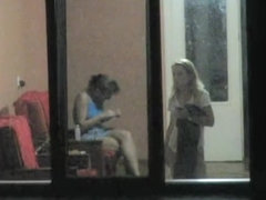 Brunette and blonde girls voyeured through hostel window
