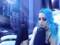 Turquoise haired gothic girl takes off stockings and worships her own feet