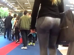 Two candid fit asses in grey yoga pants walking