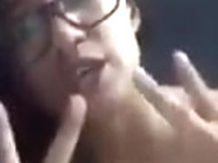 Asian chick sucking on a dildo